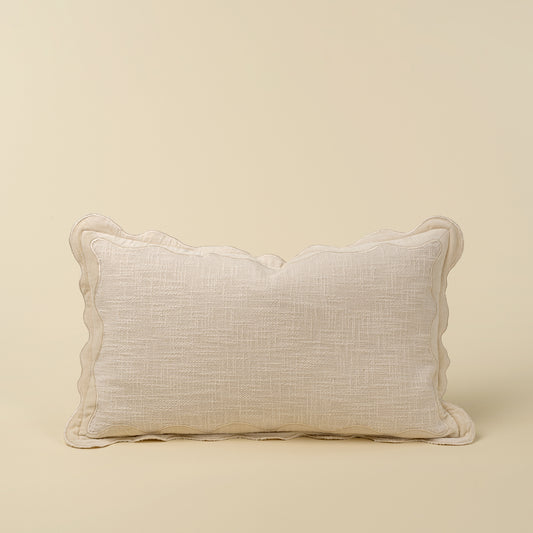 Rectangular ivory pillow with a scalloped velvet border and textured cotton body