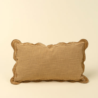 Tan textured pillow with a scalloped gold velvet border