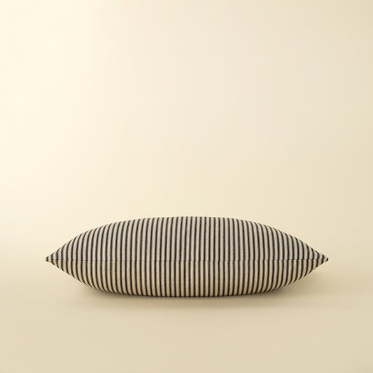 Black Ticking Pillow styled on a bed with other linens