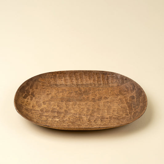 Oval hand-carved mango wood dish showing natural grain texture