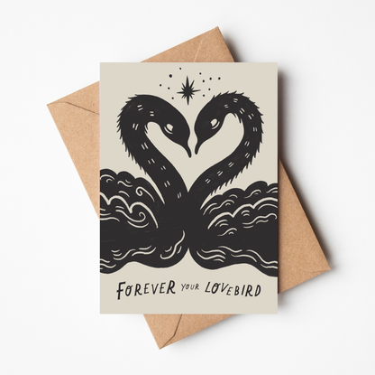 'Lovebirds' romantic card featuring two black illustrated swans forming a heart shape beneath a star, with 'Forever Your Lovebird' text, on a cream background
