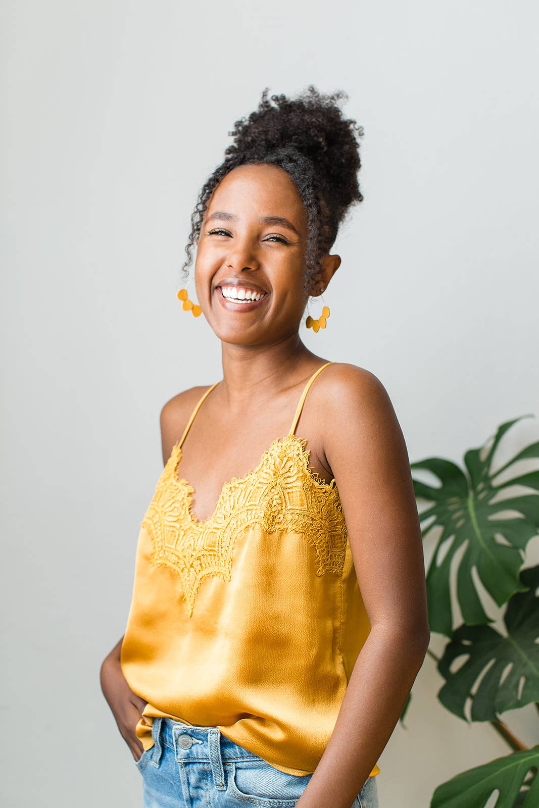 Mustard yellow leather petal hoop earrings styled with a neutral outfit