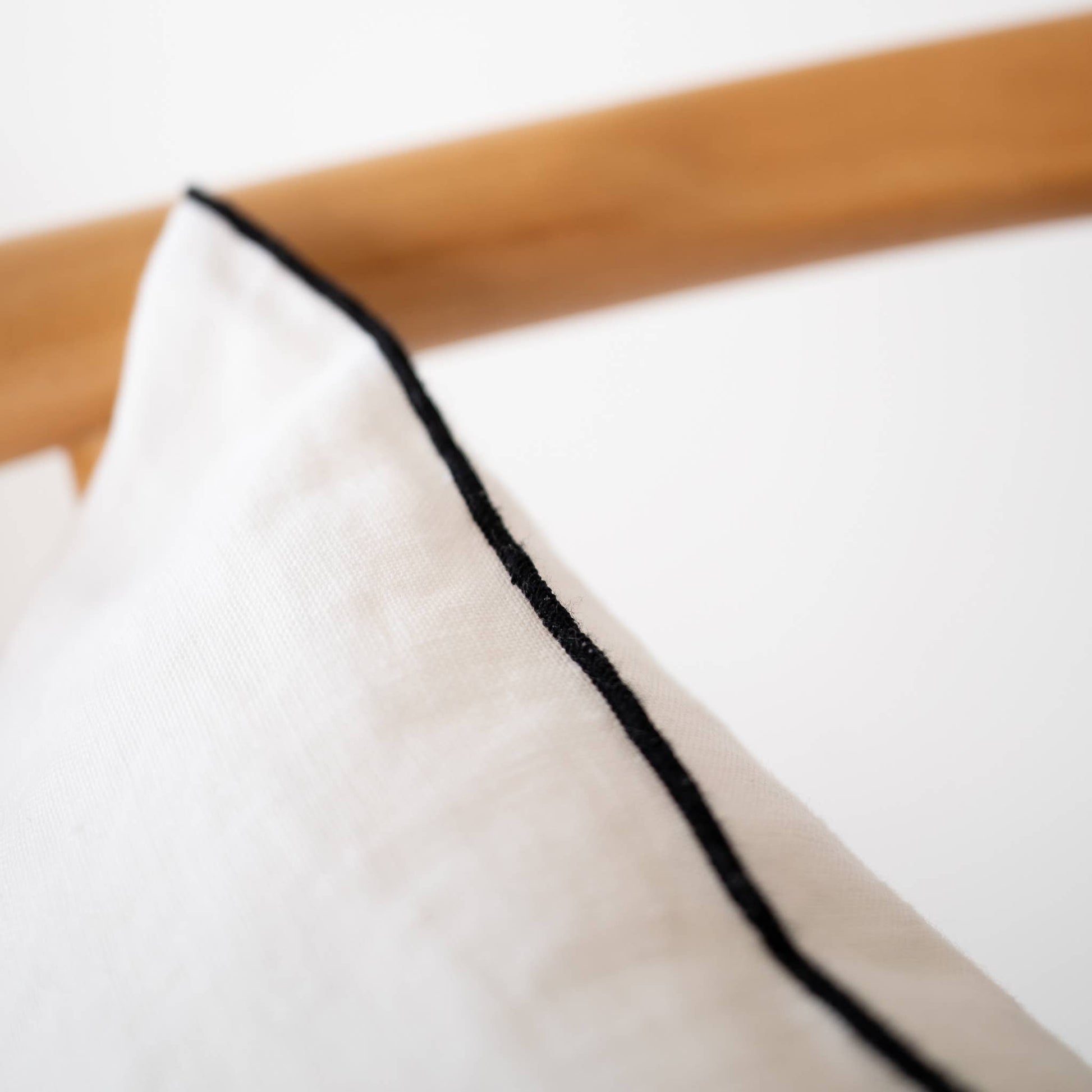 Back of the white edged linen lumbar pillow cover showing the closure