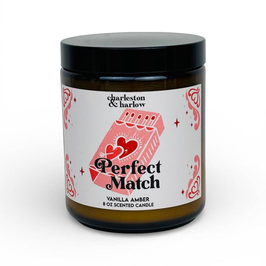 Charleston & Harlow Perfect Match soy candle in amber glass jar with cream label featuring an illustrated matchbook and heart