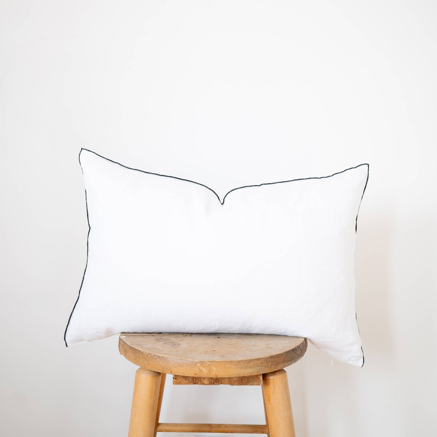 Close-up of the white linen lumbar pillow cover showing the stonewashed flax linen texture and contrast-edge trim