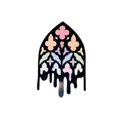 Waterproof vinyl die-cut sticker shaped like a gothic cathedral window in pastel rainbow stained-glass colours with a dripping black outline
