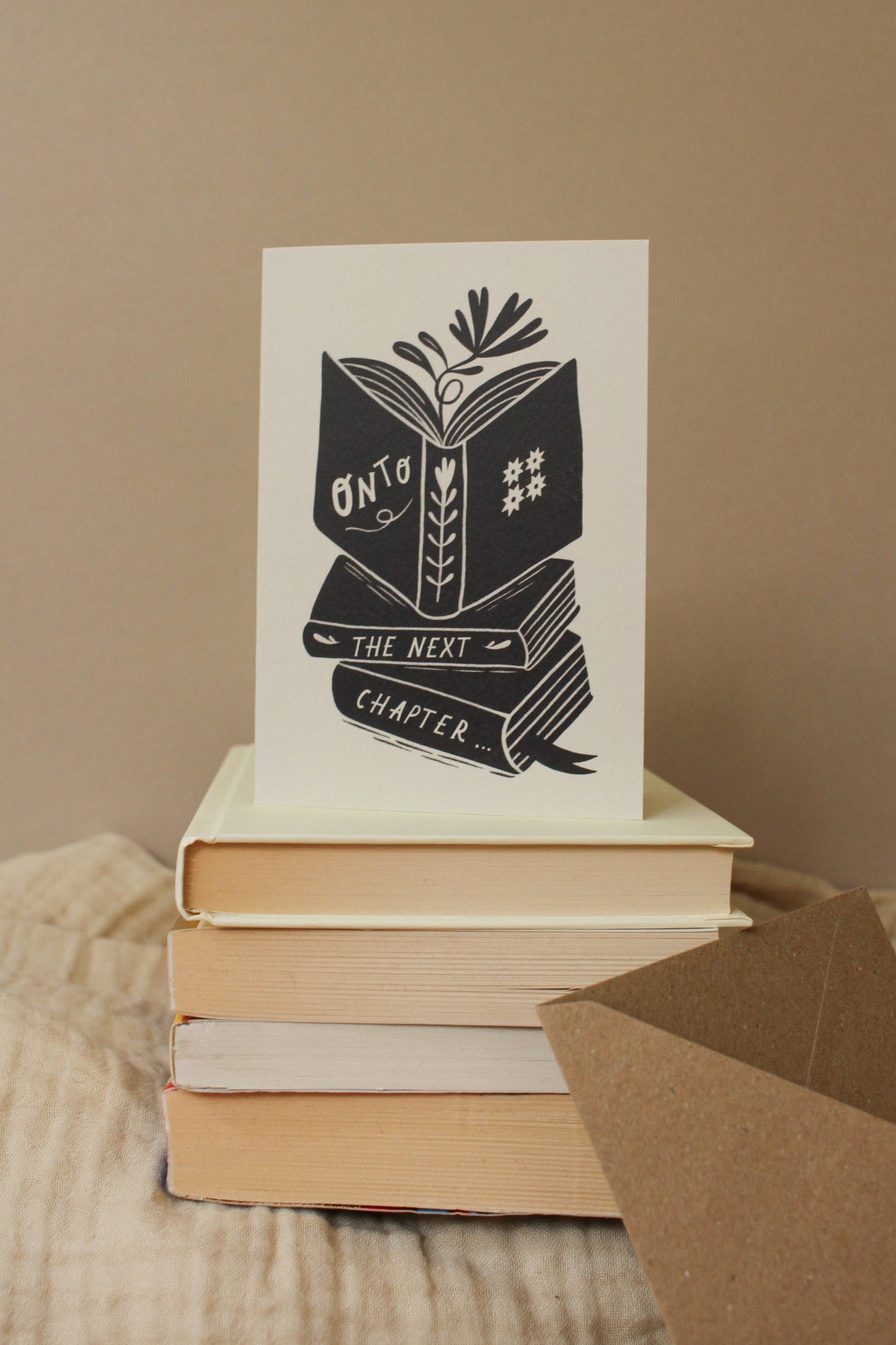 'Onto The Next Chapter...' card with kraft envelope on a light background