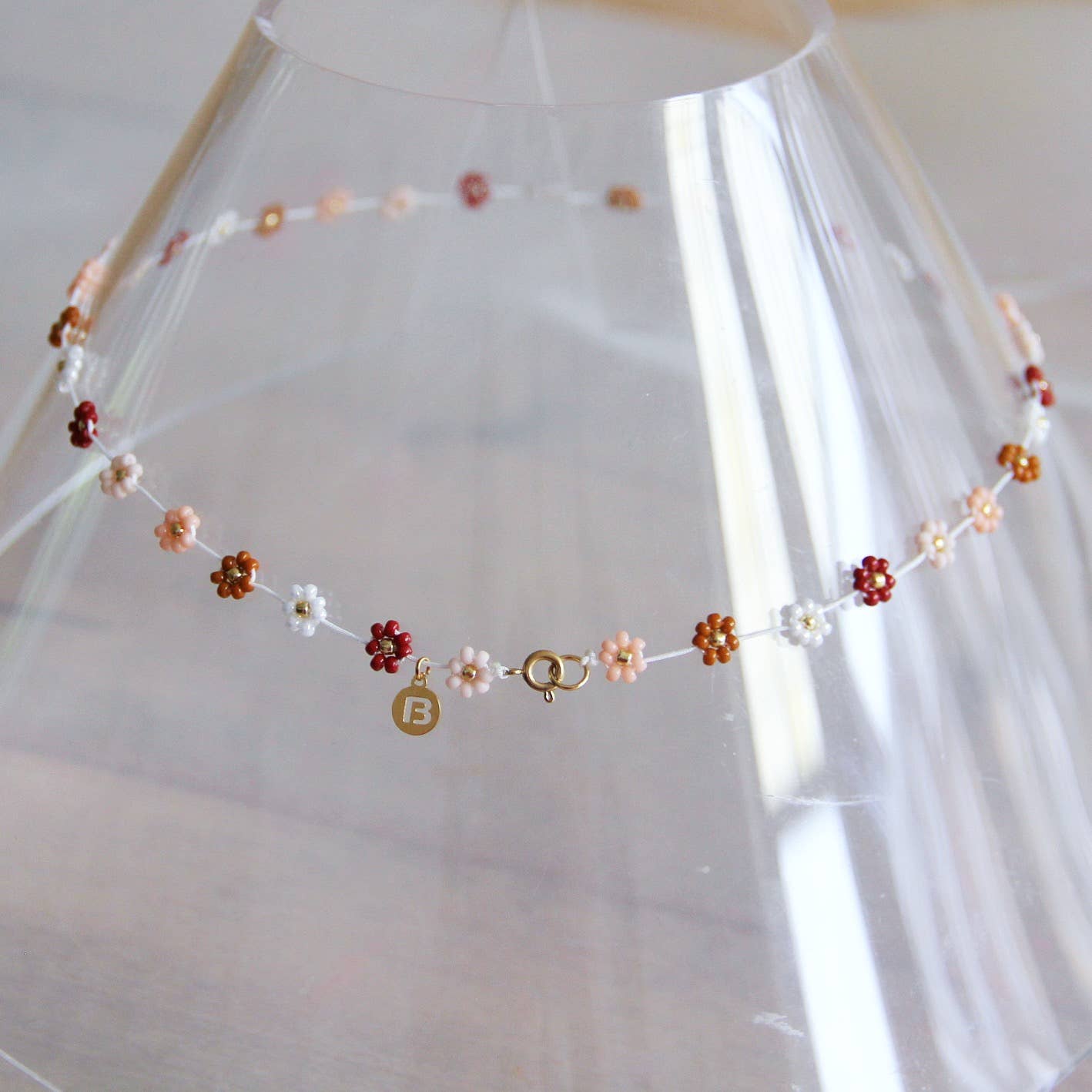 Additional angle of the handmade daisy flower beaded necklace in mixed nude tones - PABOOM