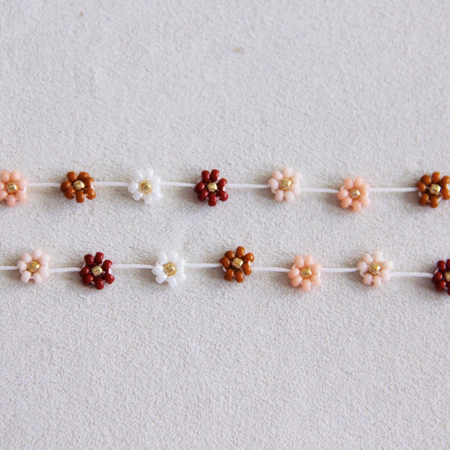 Additional angle of the handmade daisy flower beaded necklace in mixed nude tones - PABOOM