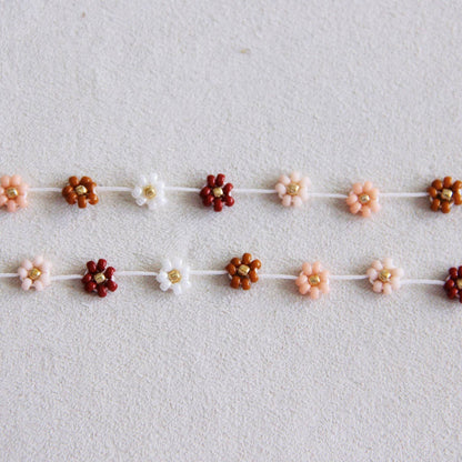 Additional angle of the handmade daisy flower beaded necklace in mixed nude tones - PABOOM
