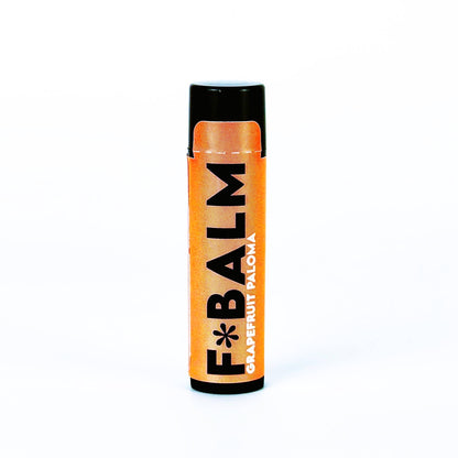 Charleston & Harlow F*Balm Grapefruit Paloma lip balm tube with orange kraft-paper label