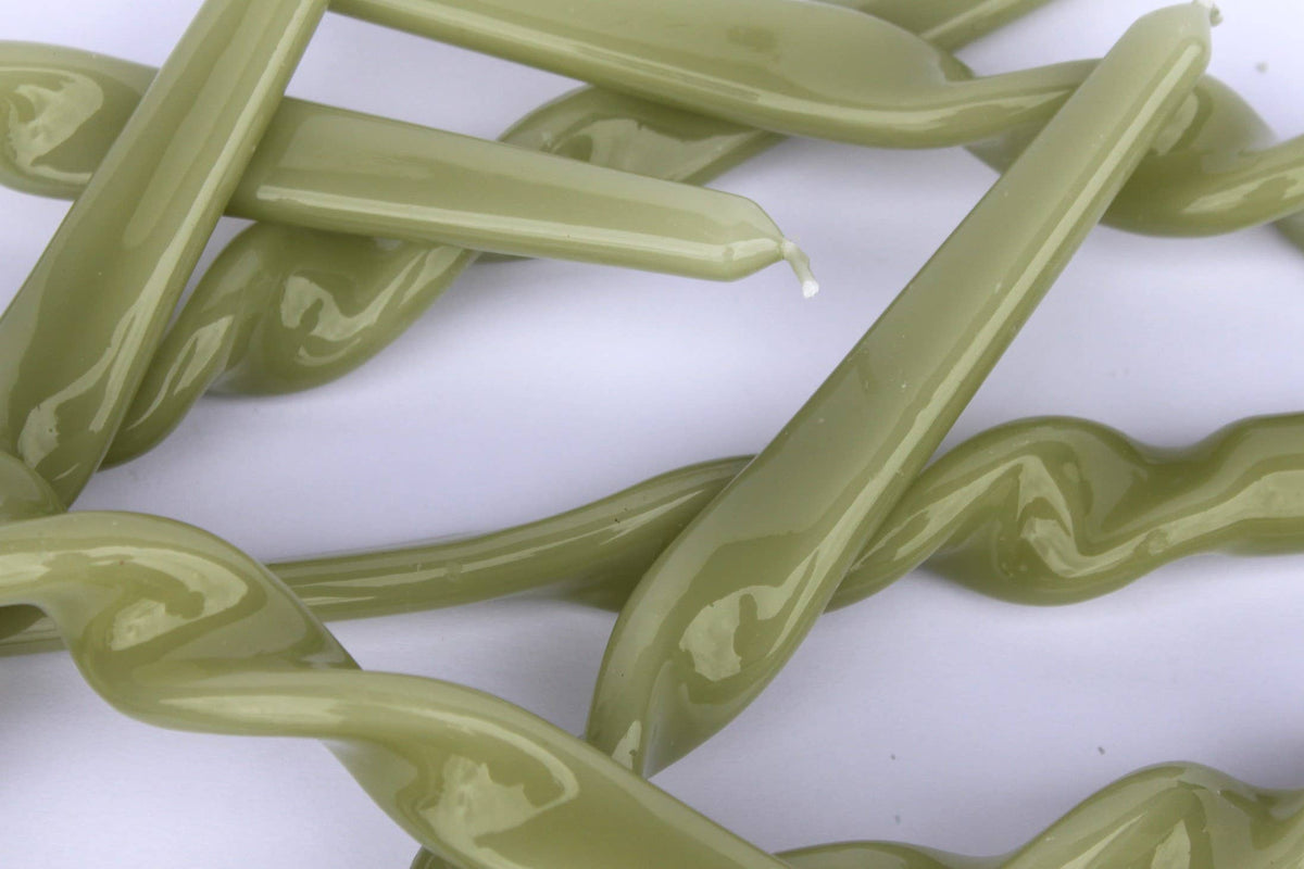 Three leaf green twist taper candles displayed inside their MÆGEN gift box