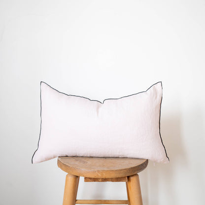 Close-up of the blush linen lumbar pillow cover showing the stonewashed flax linen texture and contrast-edge trim