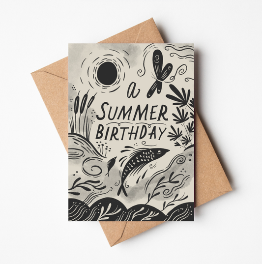 'A Summer Birthday' card featuring illustrated dragonflies, bulrushes, and a leaping fish beneath a sun, with hand-lettered 'A Summer Birthday' text