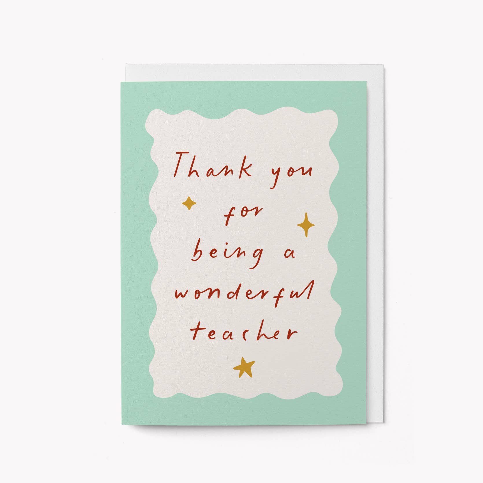 Mint green greeting card with a scalloped cream panel and handwritten red script reading 'Thank you for being a wonderful teacher,' with gold star accents
