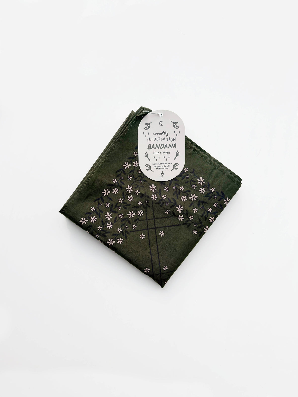 Folded dark olive green cotton bandana with a small repeating floral pattern and a Molly Illustration branded packaging tag