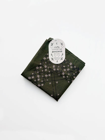 Folded dark olive green cotton bandana with a small repeating floral pattern and a Molly Illustration branded packaging tag