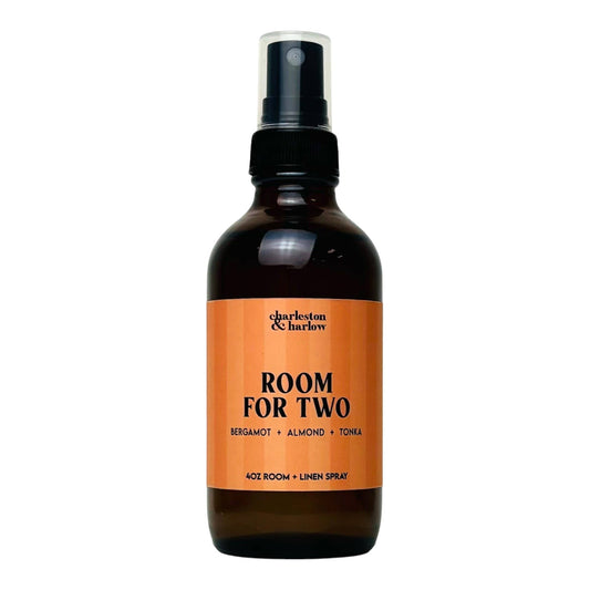 Amber glass spray bottle of Charleston & Harlow Room For Two room and linen spray with peach striped label
