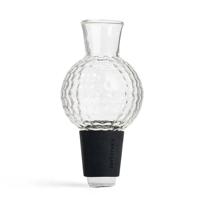 Clear glass golf-ball-shaped wine aerator with textured dimpled surface and black silicone stopper base.