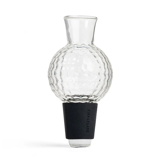 Clear glass golf-ball-shaped wine aerator with textured dimpled surface and black silicone stopper base.