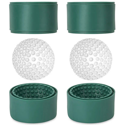 Green silicone golf ball ice molds with two clear dimpled ice balls resting on the open mold halves.