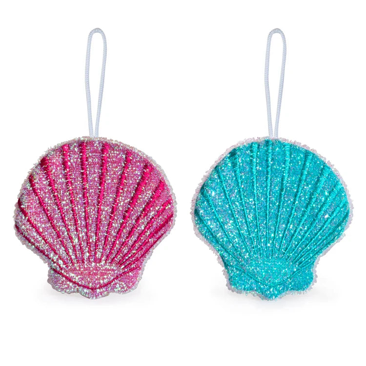 Set of two glittery seashell-shaped scrub sponges in pink and teal with a hanging loop, shown against a white background.