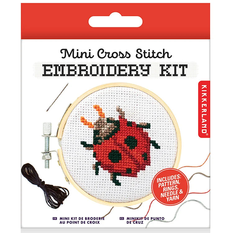 Red Kikkerland Mini Cross Stitch Embroidery Kit package featuring a ladybug pattern with bamboo hoop, needle and thread visible.
