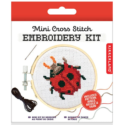 Red Kikkerland Mini Cross Stitch Embroidery Kit package featuring a ladybug pattern with bamboo hoop, needle and thread visible.