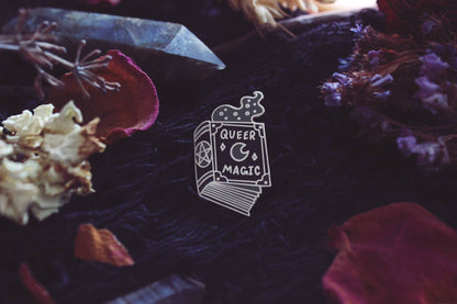 Back view of the Queer Magic pin showing the pin post and rubber back
