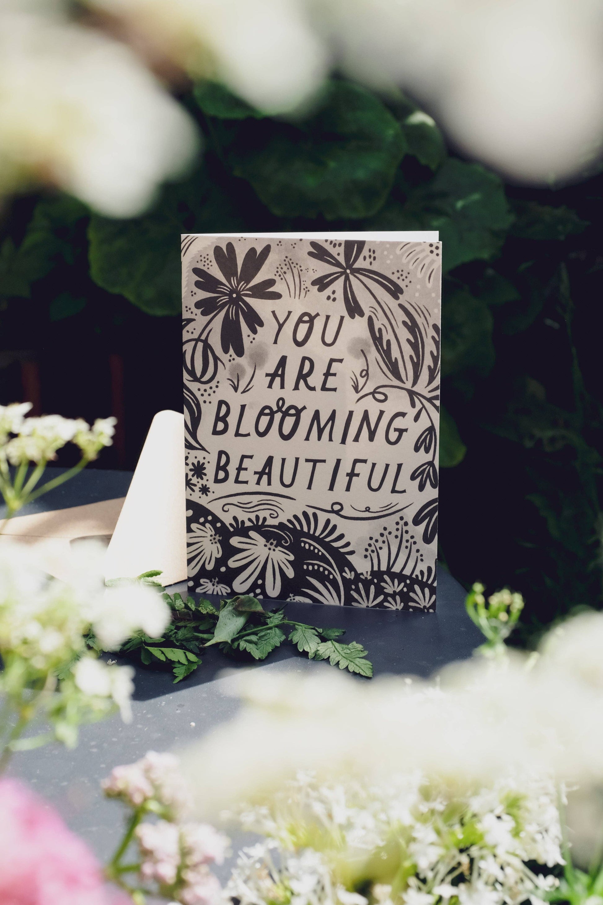'You Are Blooming Beautiful' card with kraft envelope on a light background