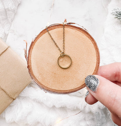Close-up of raw brass circle pendant necklace chain detail