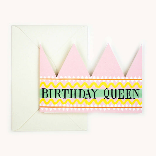 Pink party hat crown card with a mint green and yellow striped band reading 'BIRTHDAY QUEEN' in black, cream envelope behind
