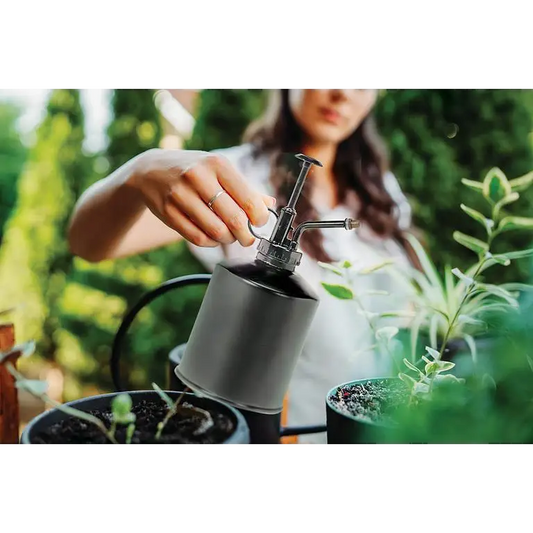 Woman misting plants with 22oz black metal plant mister – pump-action gardening tool - PABOOM
