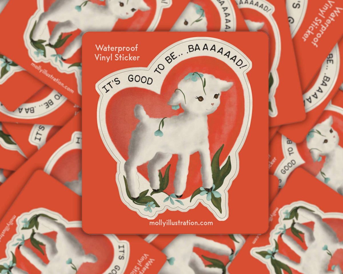 Matte vinyl sticker of a white lamb inside a heart outline on a red background with the text 'It's Good to Be Baaad'
