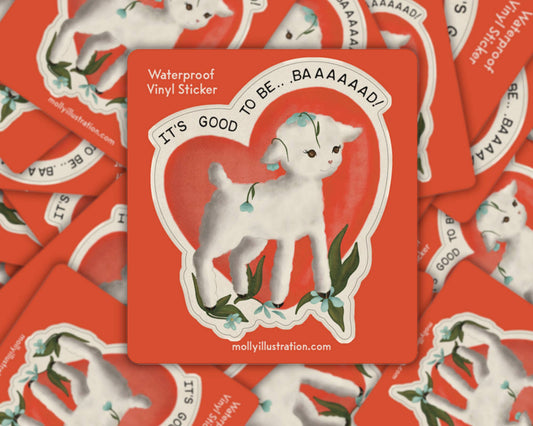 Matte vinyl sticker of a white lamb inside a heart outline on a red background with the text 'It's Good to Be Baaad'