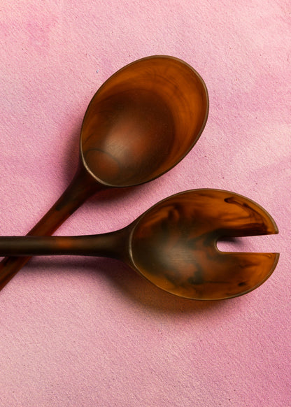 Close-up of amber resin salad servers showing swirled marble pattern