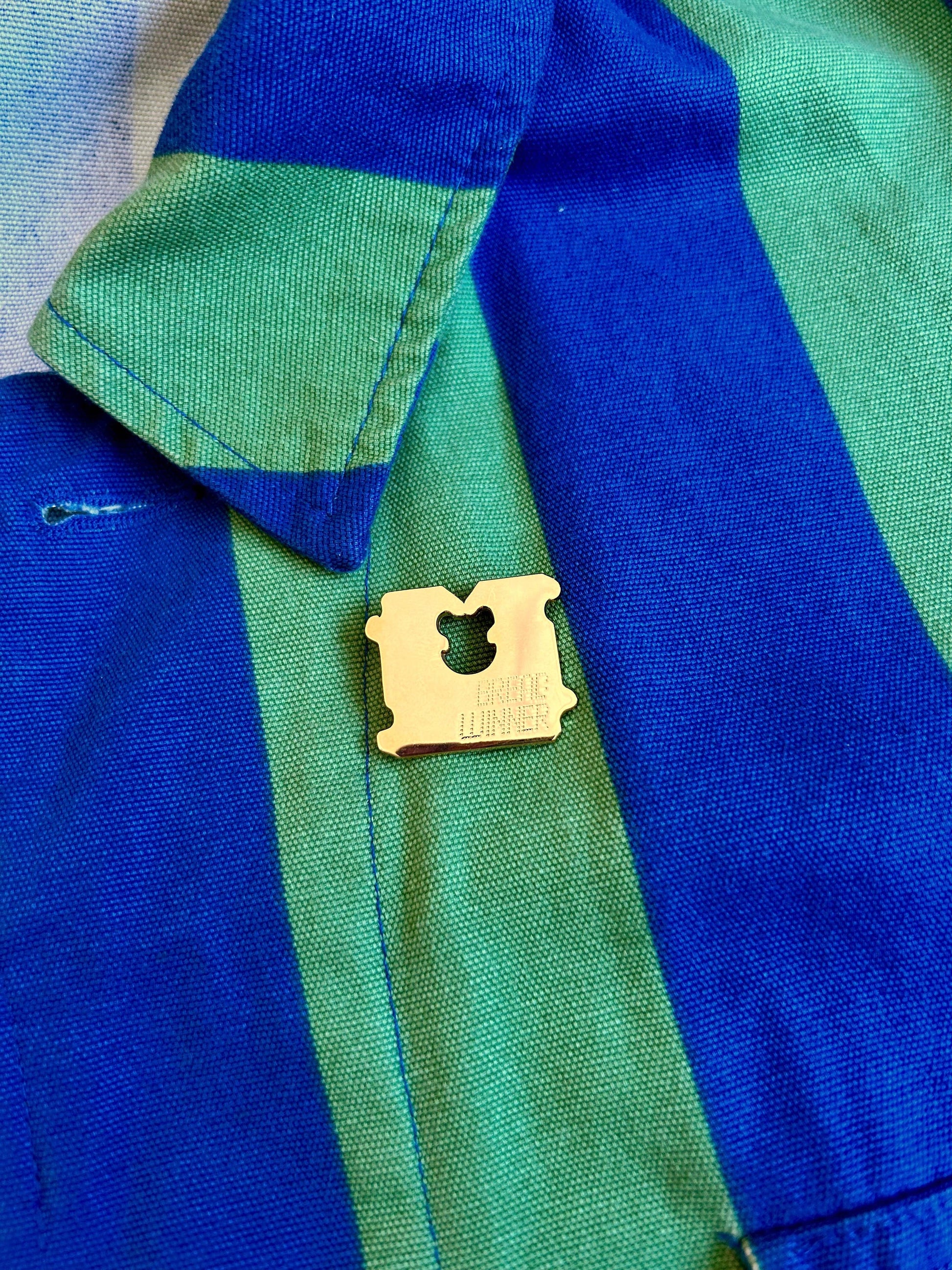 Close-up of the Bread Winner pin's gold plating and engraved text