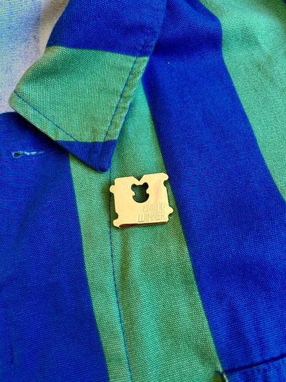 Close-up of the Bread Winner pin's gold plating and engraved text