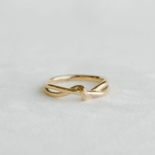 Everly Knot Ring featuring a delicate gold knot design on a light surface - PABOOM