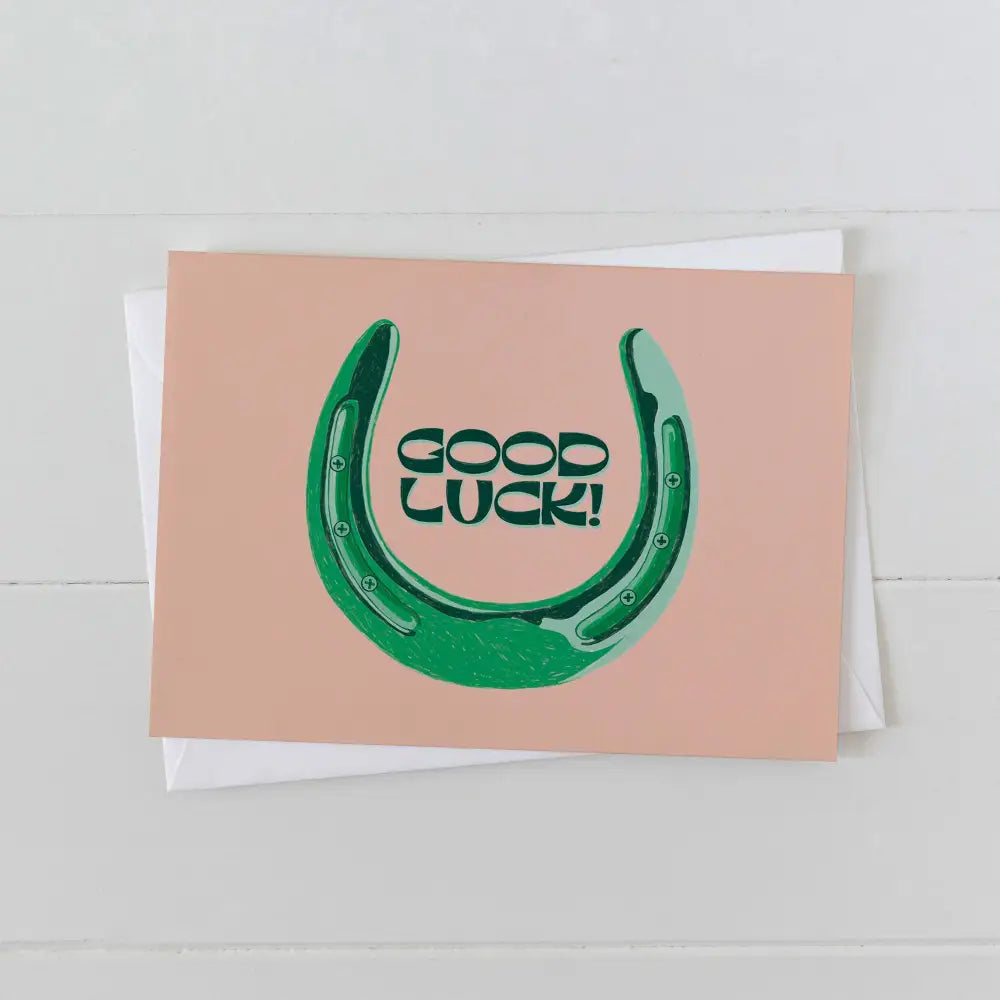 Artbaby greeting card on pink card stock and green font "GOOD LUCK" with green horseshoe surrounding text
