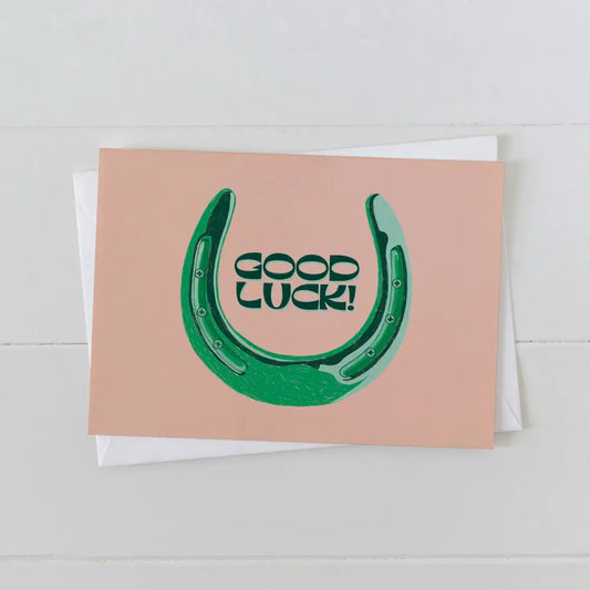 Artbaby greeting card on pink card stock and green font "GOOD LUCK" with green horseshoe surrounding text