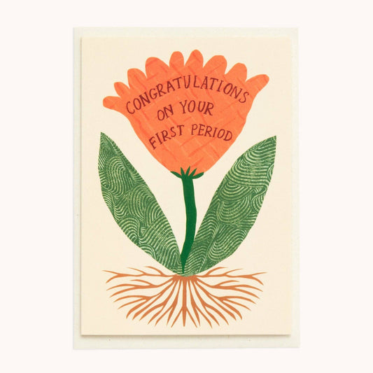 Cream greeting card with an illustrated orange collaged flower whose petals read 'Congratulations on Your First Period,' green leaves and roots below