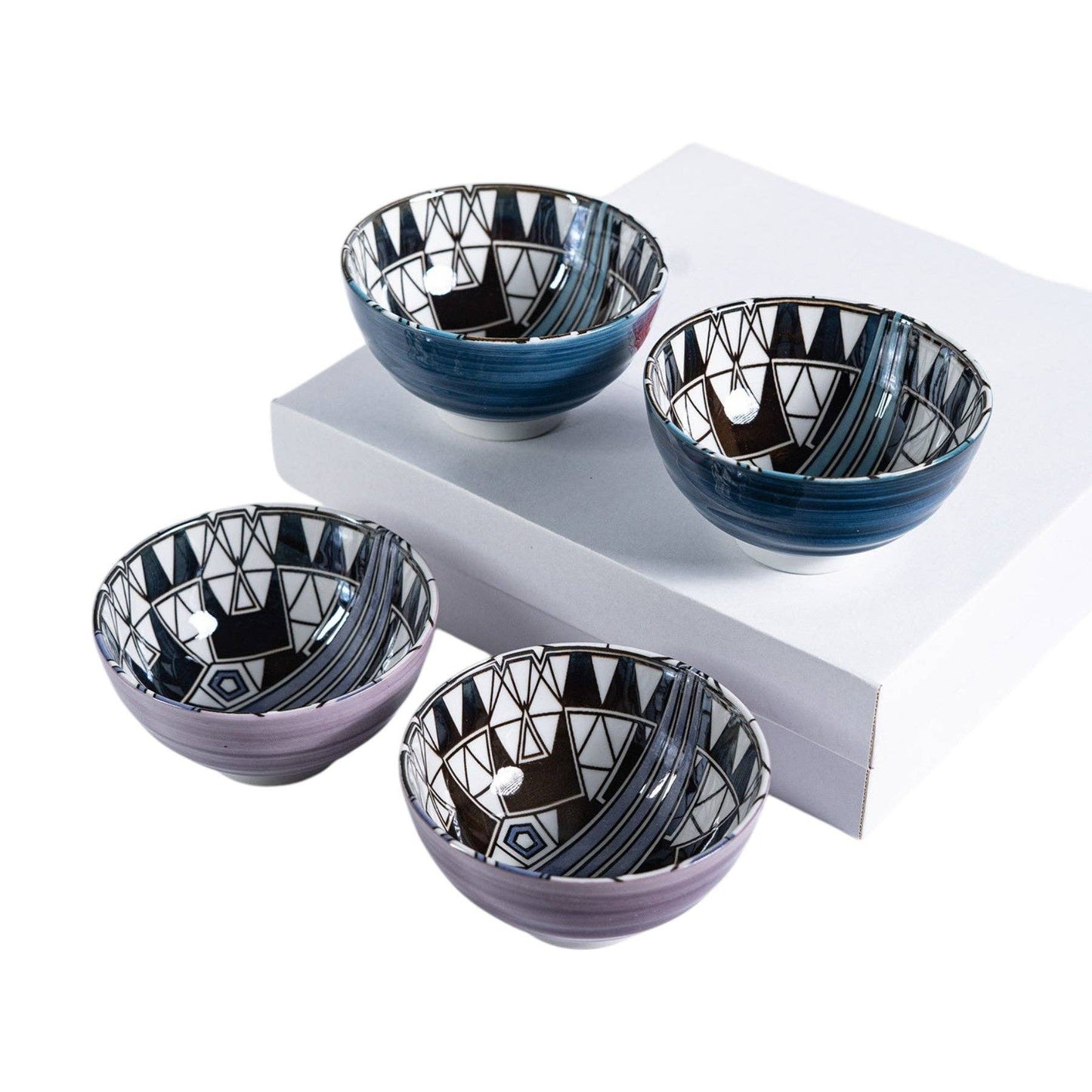 Four Frank Lloyd Wright Peacock-pattern porcelain bowls in blue-black and plum-black Art Deco geometric designs, two raised on a white pedestal box