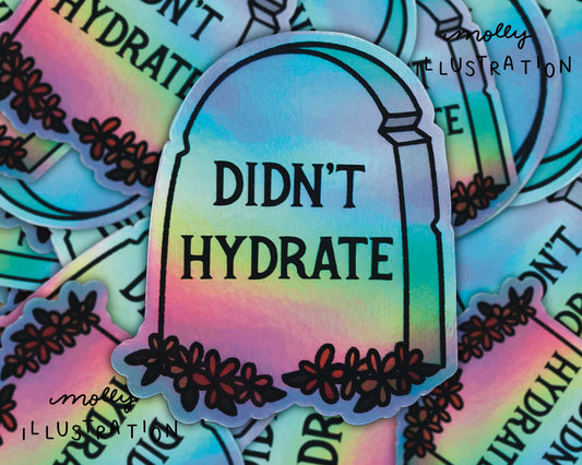 Holographic vinyl sticker of a cartoon tombstone with 'Didn't Hydrate' written on it, surrounded by smaller matching stickers