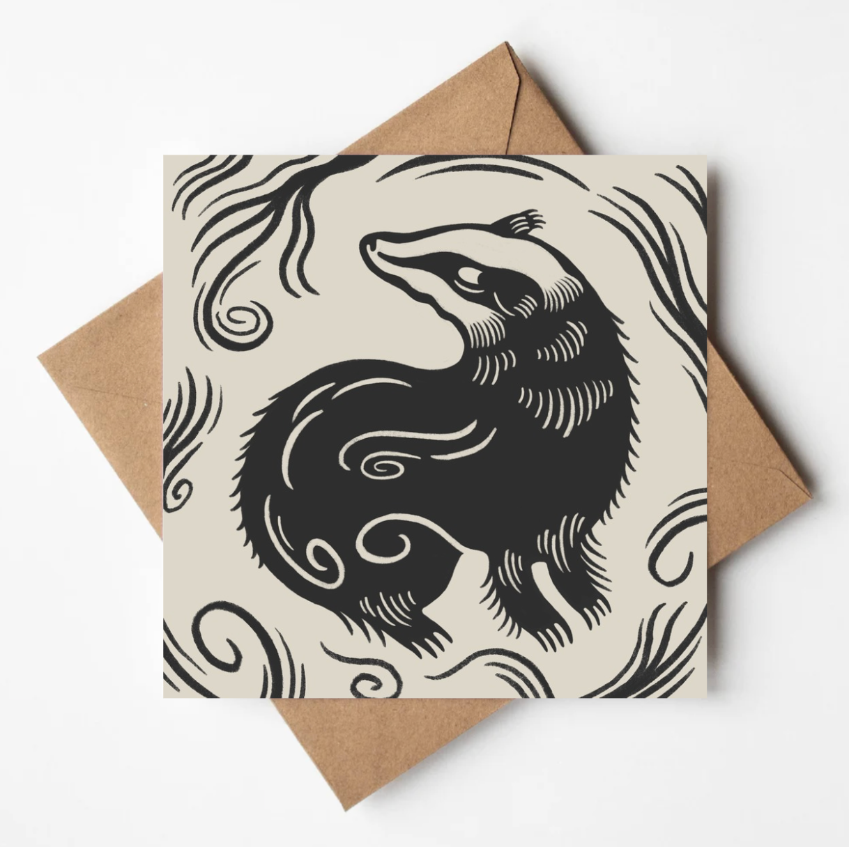 'The Badger' animal card featuring a bold black linework illustration of a badger curled amid swirling branches, on a cream square card