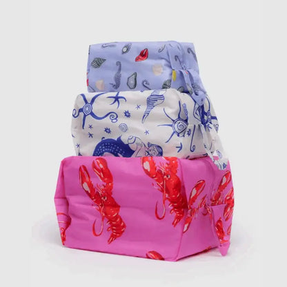 BAGGU 3D Zip Set Sea Creatures - three zippered travel pouches stacked with lobster, seashell, and sea creature prints - PABOOM