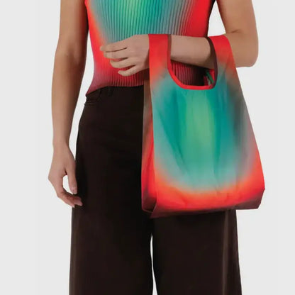 Baby Baggu featuring a gradient from red to turquoise being held on the arm - PABOOM