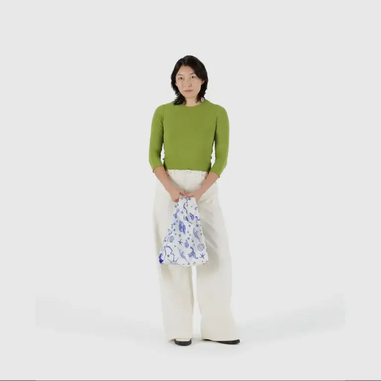 Baby Baggu bag featuring a mermaid pattern being held in the arm