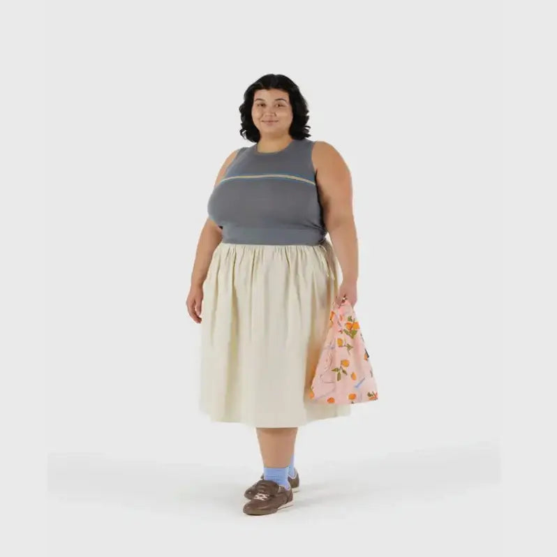 Baby Baggu bag featuring a pattern of apricots and ribbons being held in the hand - PABOOM