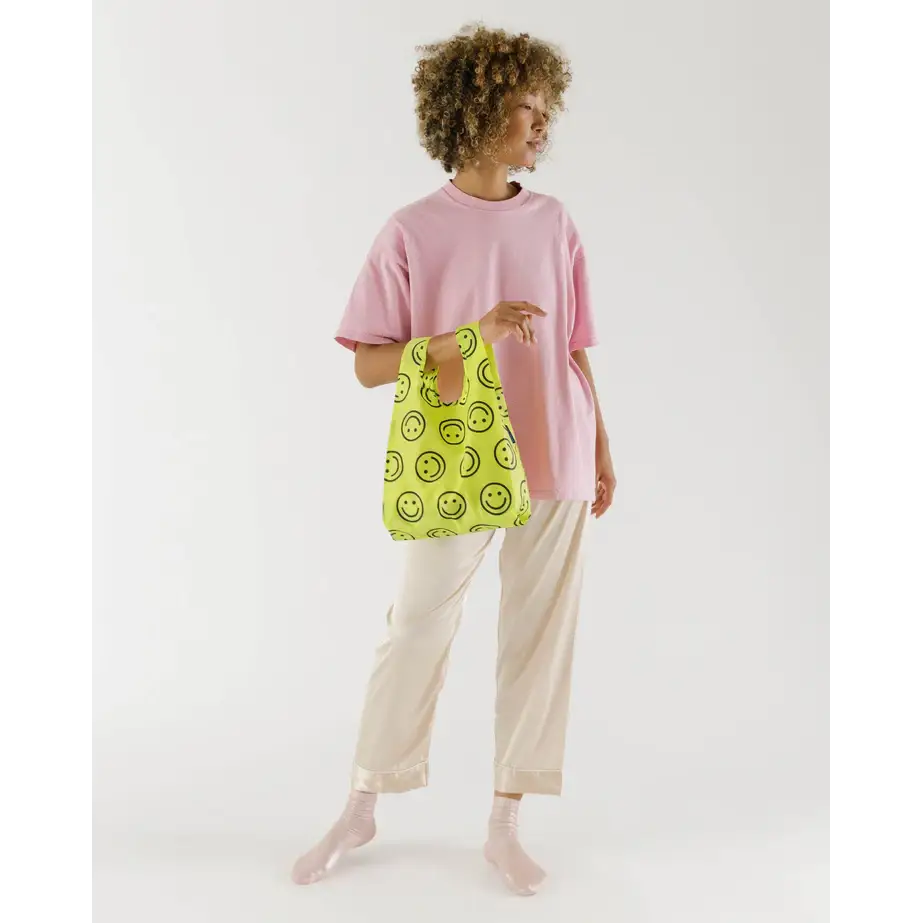 Baby Baggu bag with smiley face pattern being held in the arm - PABOOM